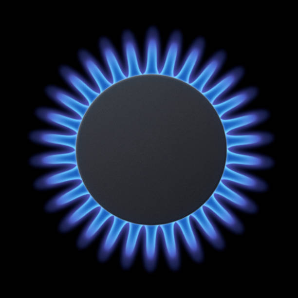 Gas burners with blue flame on black background.